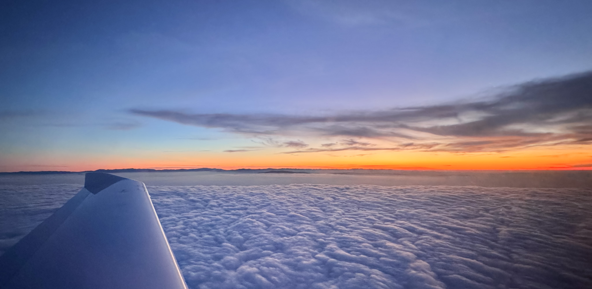 Flying above a cloud layer at sunset